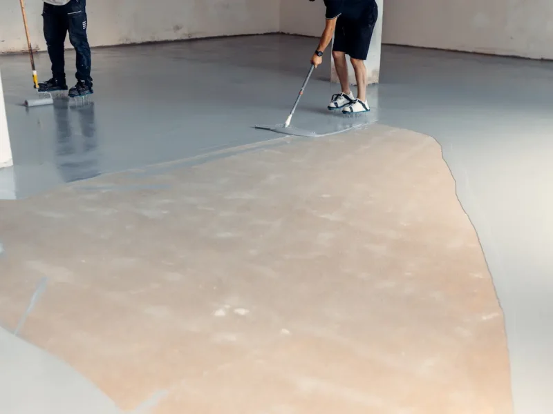 workers-applying-epoxy-coating-to-concrete-floor-2026-01-09-11-33-25-utc